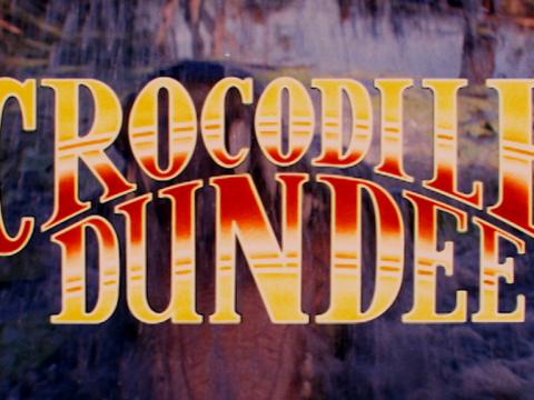Still from the trailer for Crocodile Dundee with the title of the film written in large letters