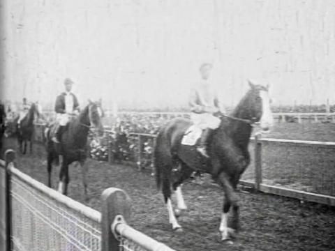 Horses and jockeys enter the racetrack at the 1924 Melbourne Cup