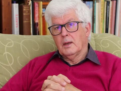 Anthony Buckley seated at home with his hands clasped being interviewed.