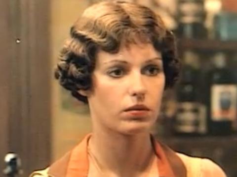Film still of Helen Morse as Caddie working in a pub looking stunned.
