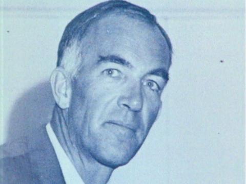 Architect Jørn Utzon in a blue tinted photograph. He is looking at the camera.