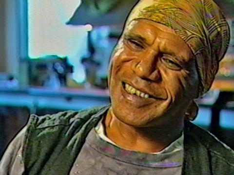 Close up of musician and songwriter Archie Roach, wearing a bandanna covering his head and smiling. 
