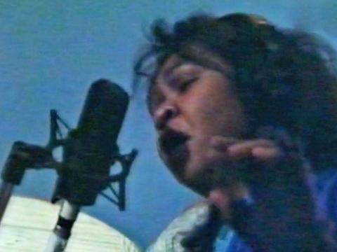 Close up of musician Ruby Hunter singing into a microphone.