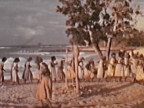 Aboriginal women performing a ceremony in a circle by the sea