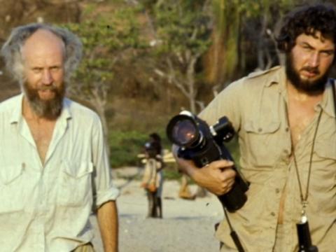two men, one carrying a movie camera