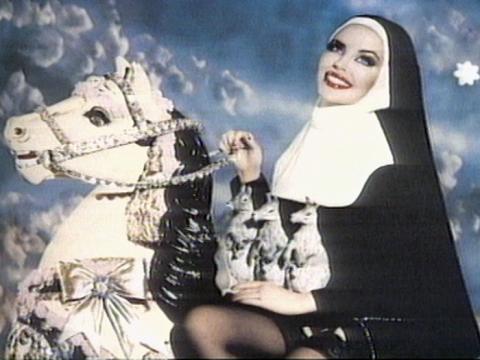 Part of an artwork by Pierre et Gilles of Kylie Minogue dressed as a nun and riding a rocking horse with three tiny kangaroos sitting in her lap.