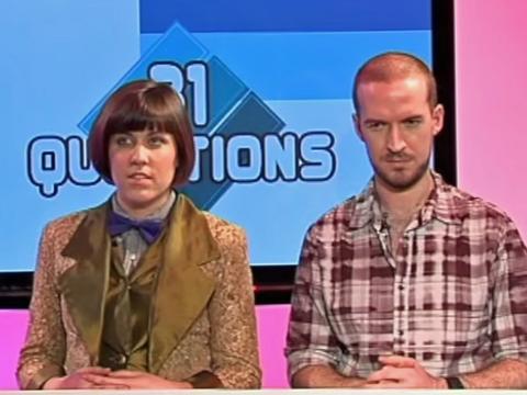 Two game show contestants standing side-by-side in front of a screen that says 31 Questions. 