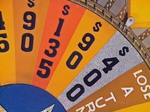 A section of a game show wheel with different dollar amounts written on each section and one section that says Lose A Turn.