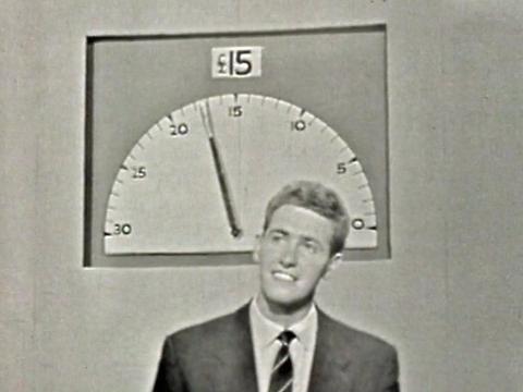 A young man standing underneath a big 30-second timer.