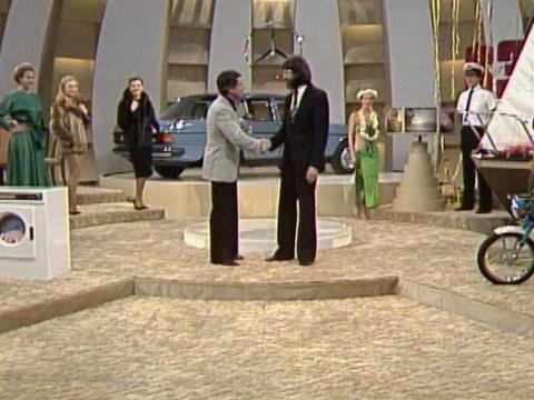 TV studio with game show prizes and models in the background