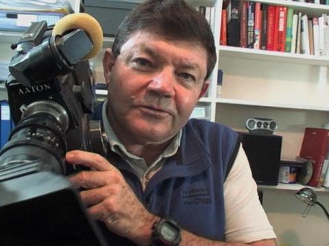 Filmmaker Bob Connolly holds a camera in his studio