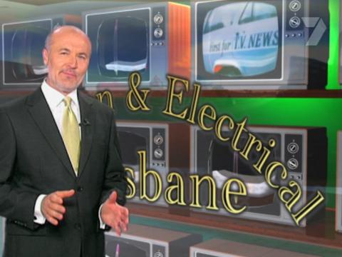 A presenter stands in front of a shop window full of colour television sets