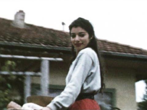 Beautiful Mirka Mora standing outside a house carrying picnic food