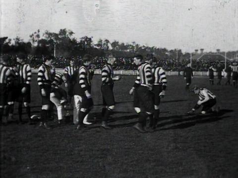 Black and white still of a football team in striped jerseys