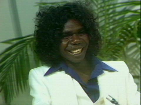 David Gulpilil laughing as he is being interviewed on the Mike Walsh Show in the studio.