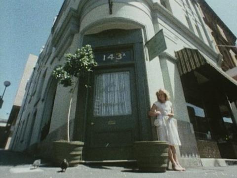 A woman stands outside of a historic building in The Rocks in Sydney