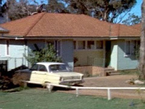 A pale yellow car sitting in the driveway of a suburban house in Sydney's Green Valley