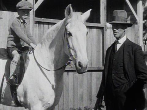 Gerald 'Cappy' Telford riding the white pony Millie. Standing next to them is trainer HR Telford, Phar Lap's part-owner and trainer.
