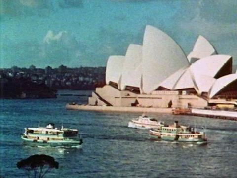The Sydney Opera house with ferries and a hydrofoil sailing in front of it.