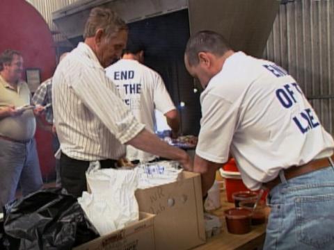 Men serving food with T shirts reading 'The End of the Line'.