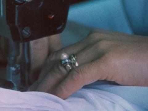 Close up of a woman's hands working a sewing machine.