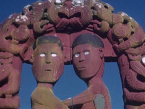 Maori carvings of two figures under an arch
