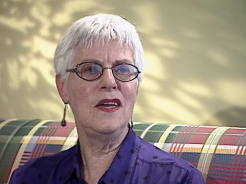 An older woman is sitting down for an interview.