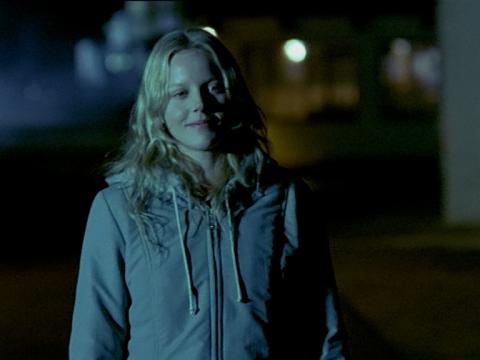 Abbie Cornish in a still from Somersault. She is smiling. It is dark and her face is in shadow.