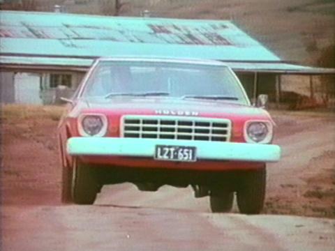 A Holden car drives along a dusty road