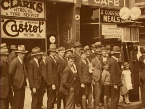 A crowd gathers to watch the Hoyts cinema 'touring talkie' truck refuel at a service station, circa 1929