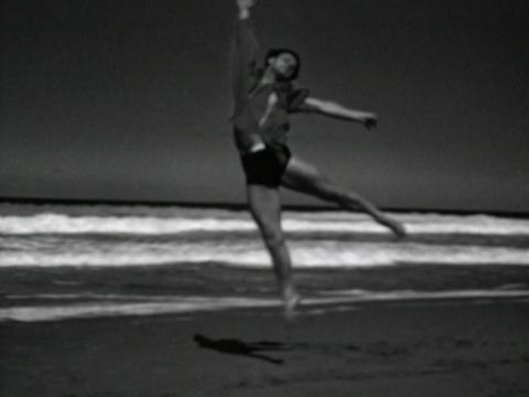 Screenshot of a solo dancer from Ballet Russes performing a dance routine on the shoreline of Bungan Beach, circa 1936.