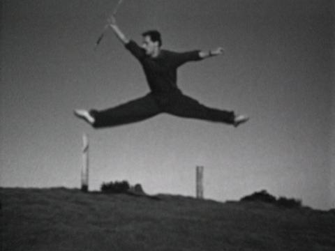 Screenshot of home movie of Ballet Russes dancer performing a dance routine on a grassy slope. Circa 1936.
