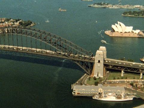 A long shot of the Sydney Harbour Bridge and Opera House seen from the air