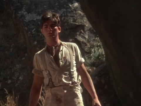 Albert, played by John Jarratt, looks through a gap in the rocks