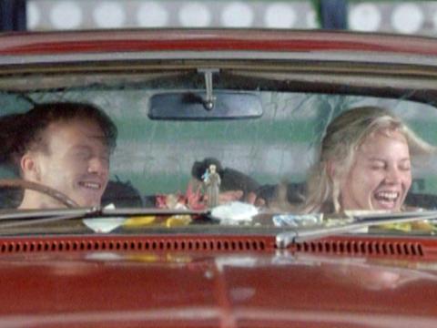 Heath Ledger and Abby Cornish as Dan and Candy sit inside a red car going through a car wash. They are both laughing in a drugged ecstasy.