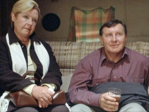 Noni Hazlehurst and Tony Martin as Mr and Mrs Wyatt, sitting on a couch.