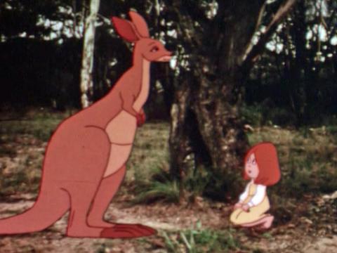 An animated red kangaroo and small girl face each other in the bush. The still is a scene from the animated film Dot and the Kangaroo (1977). The animated characters are set within actual footage of the bush.