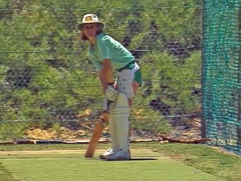 A batswoman from the Australian Women's Cricket team holding a cricket bat in the practice nets.