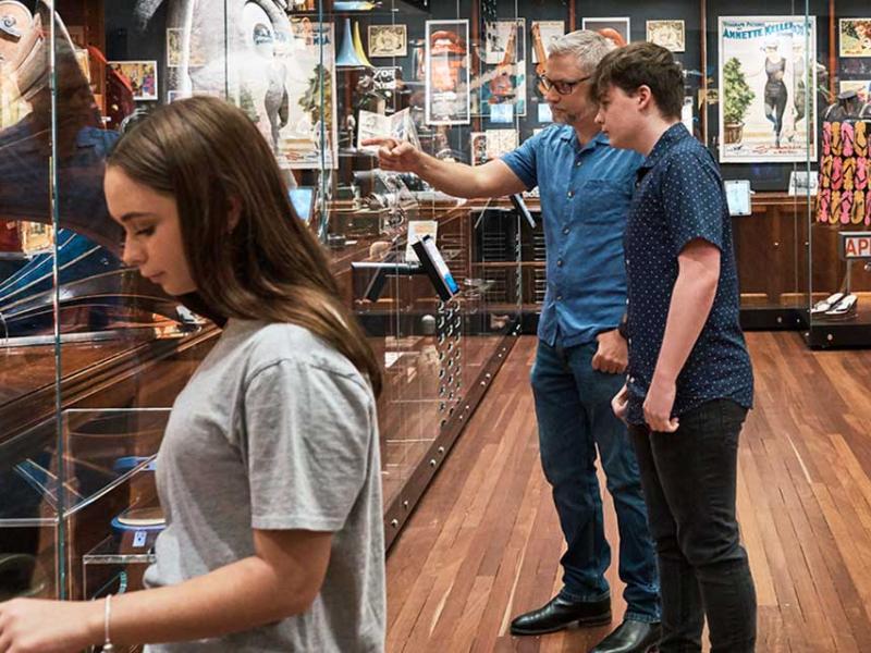 People looking at items in an exhibition space.