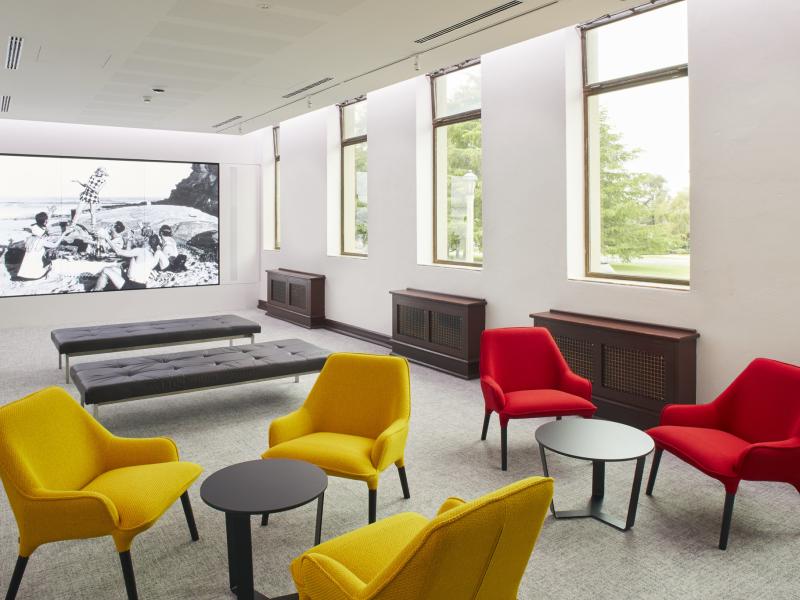 Image of carpeted room with large screen at one end and chairs at the other