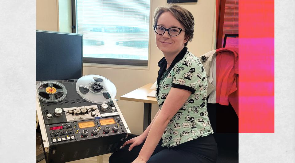 NFSA curator Amy Butterfield, seated and looking up at the camera. She is sitting next to some audio equipment