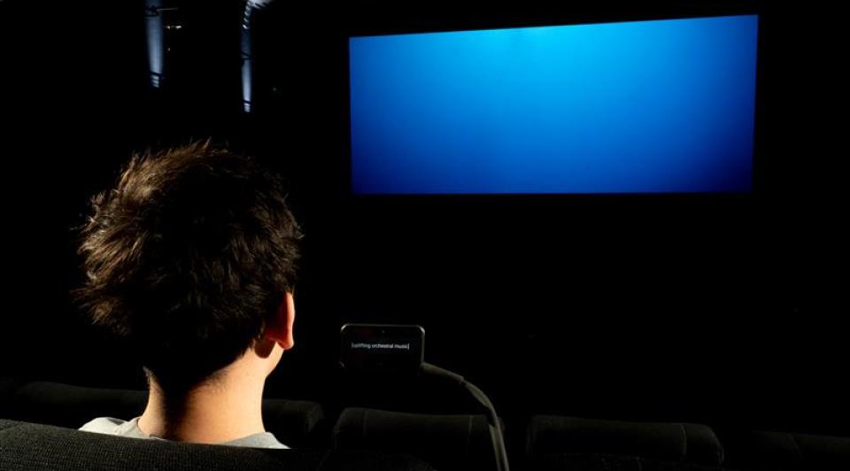 Back of a person's head watching cinema screen