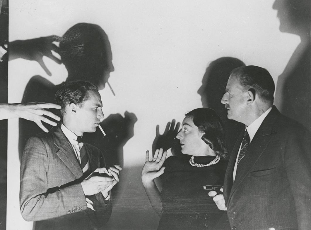 Peter Finch standing with a young woman and older man in profile. There are some menacing shadows behind them and the woman looks frightened.