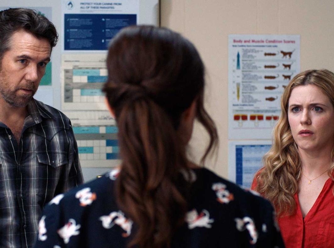 A man and woman looking at another woman who has her back to the camera.