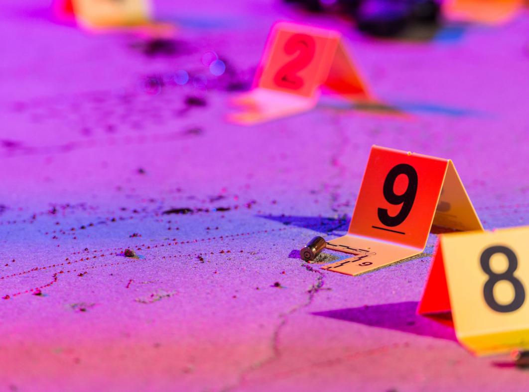 Crime scene markers on the ground under neon lighting