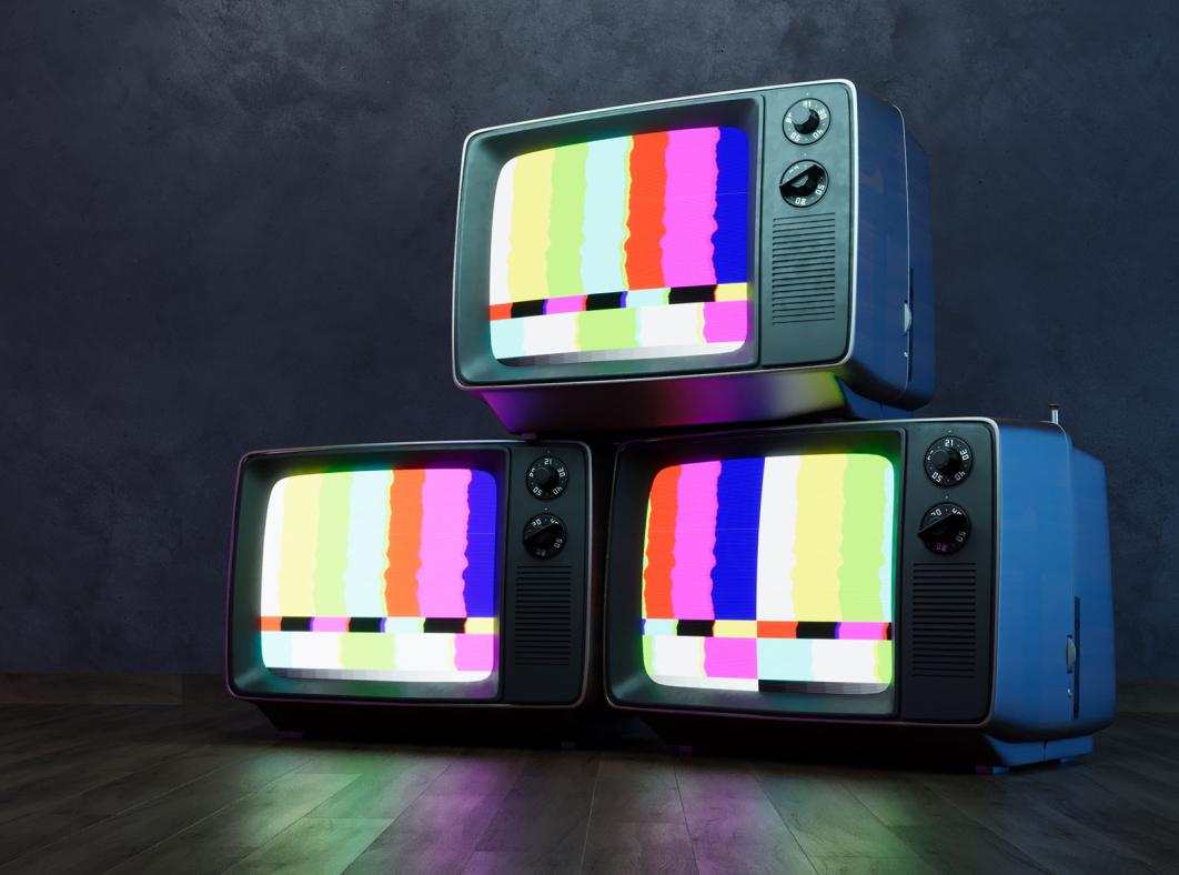 Three television sets stacked on top of each other displaying a coloured test pattern. 