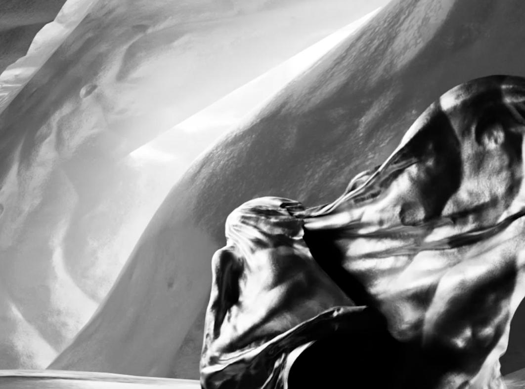 Detail from the art installation Inferno showing a figure wrapped in a billowing fabric standing before sand dunes.