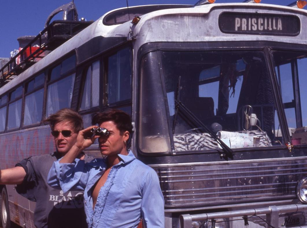 Director Stephan Elliot and Guy Pearce look out across the stony gibber desert with the bus in the background.