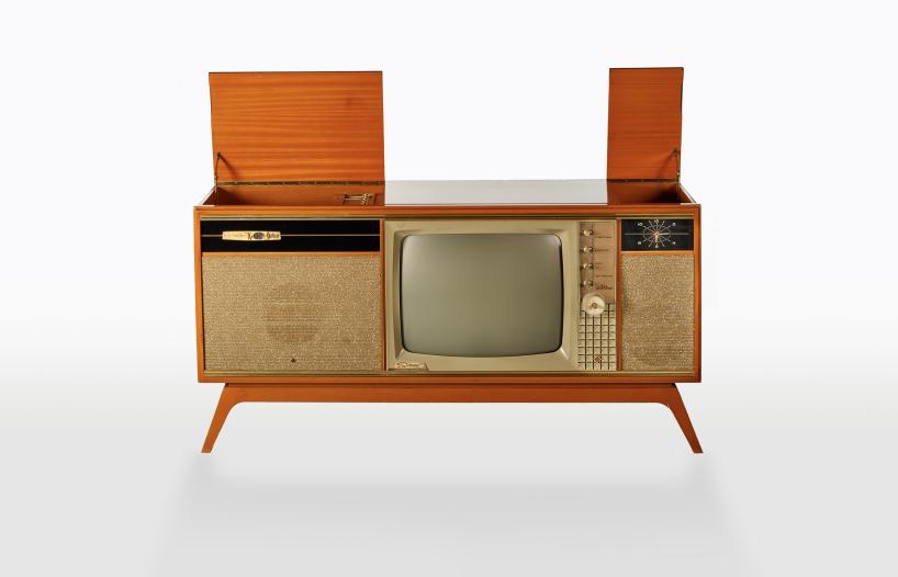 A home entertainment unit from the 1960s with a television, turntable and radio all housed in a large wooden unit.