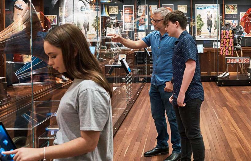 People looking at items in an exhibition space.